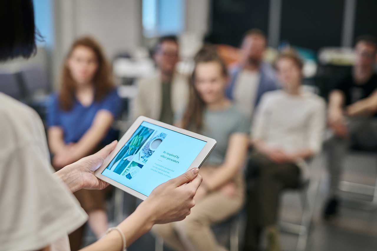 Woman holding a tablet screen with audience in background